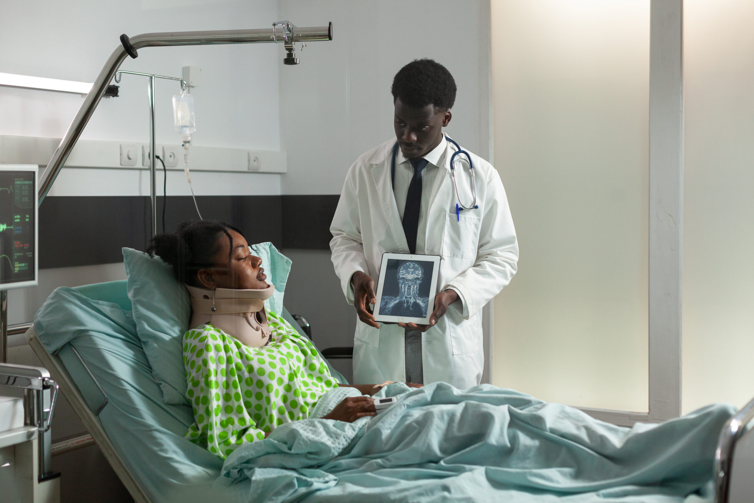 African american therapist doctor explaining radiography expertise to sick woman African american therapist doctor explaining radiography expertise to sick woman discussing healthcare treatment during medical appointment in hospital ward. Patient with neck cervical collar